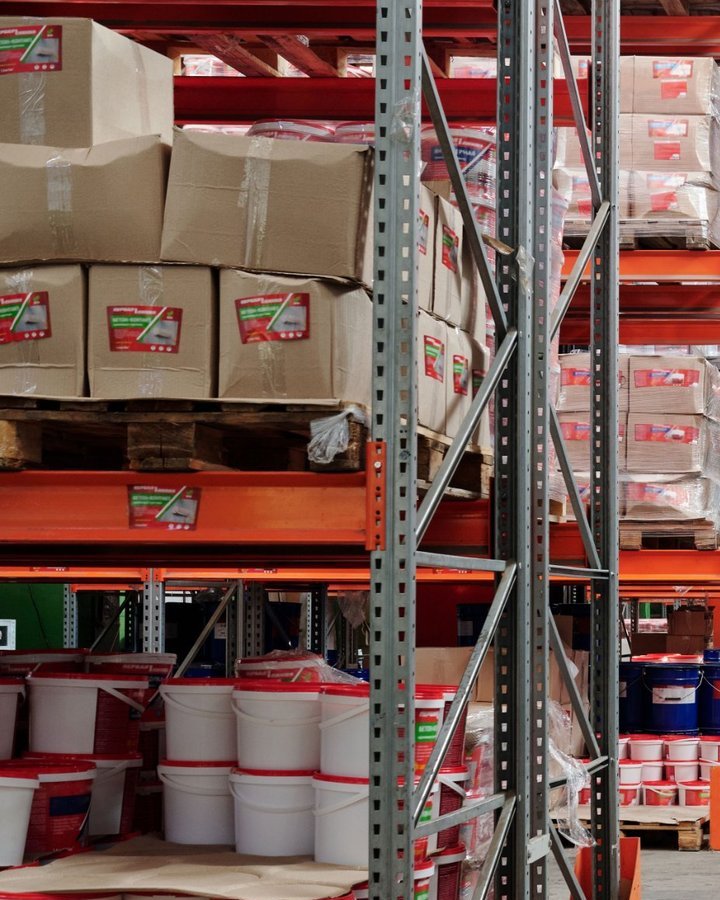Estanterías con cajas y baldes sobre pallets